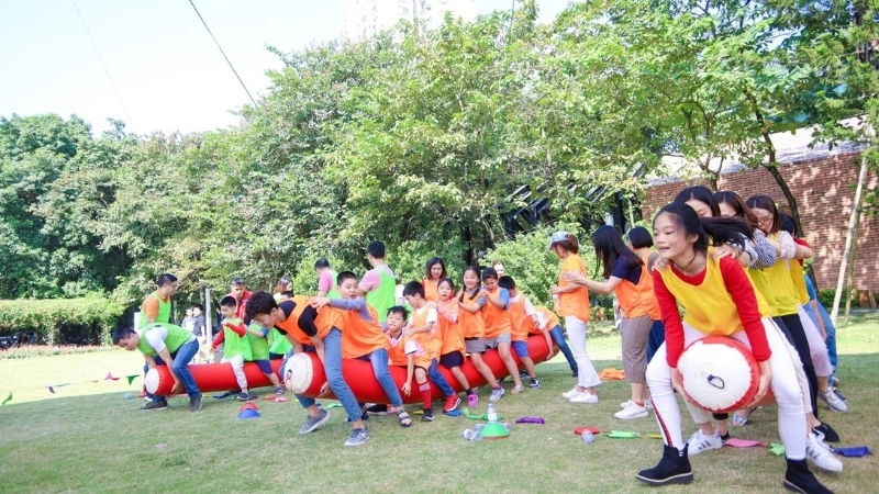 Tập thể cùng nhau tham gia trò chơi đua thuyền trên cạn bãi biển đầy sôi động