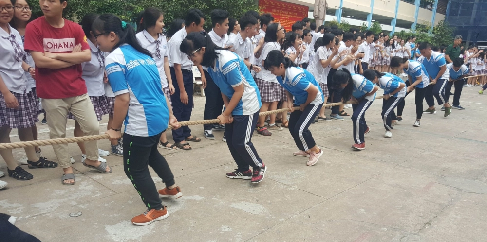 Các thành viên nỗ lực dùng sức mạnh đôi chân trong trò chơi kéo co ngược tại hội thao