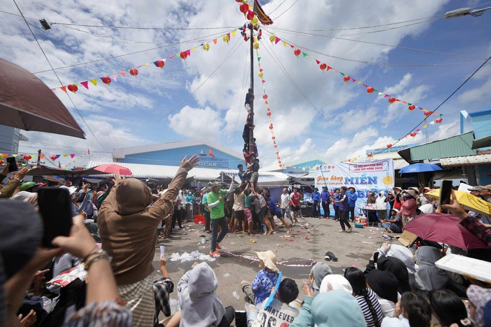 Hình ảnh trò chơi leo cột mỡ sôi động giữa đám đông
