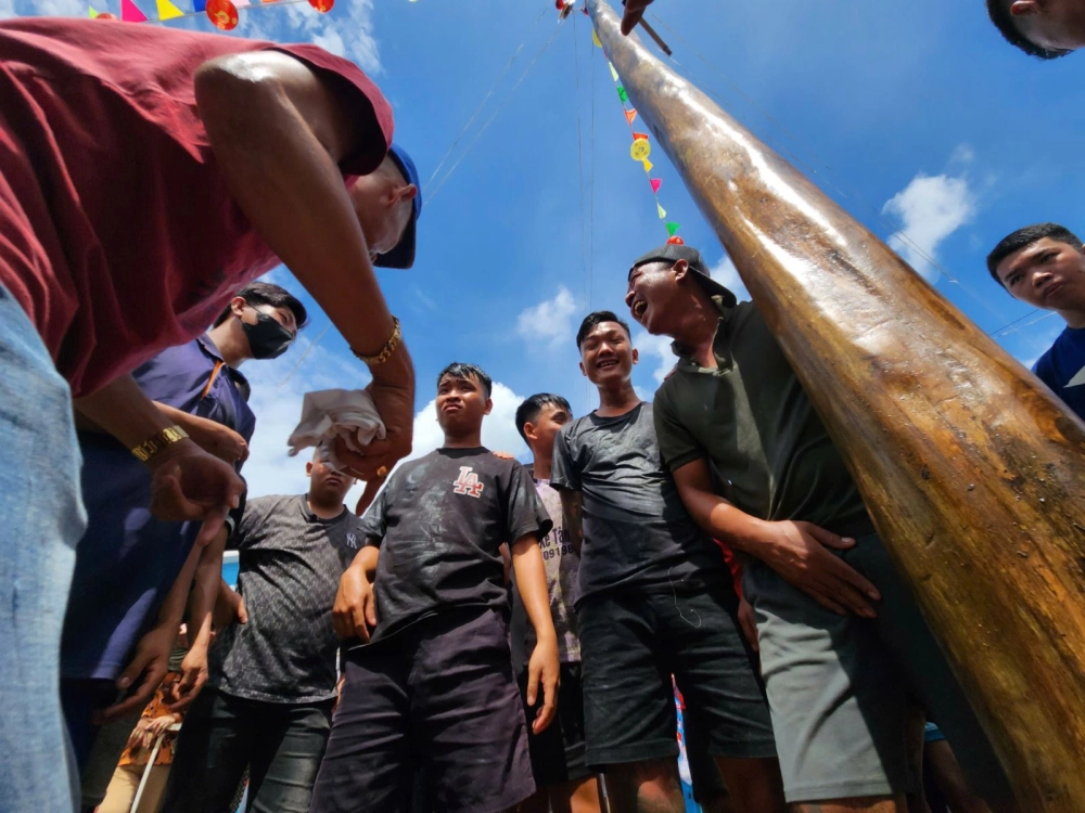 Hình ảnh leo cột mỡ đầy kịch tính và tiếng cười