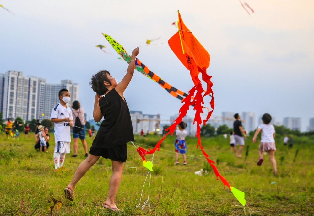 Bé thả diều hồn nhiên dưới bầu trời mùa hạ