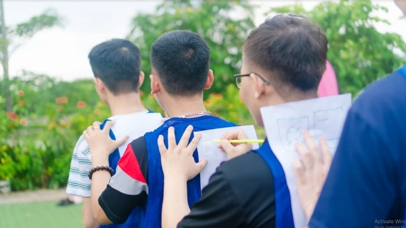 Một nhóm học sinh hào hứng tham gia trò chơi truyền tin cho trẻ em tại sân trường