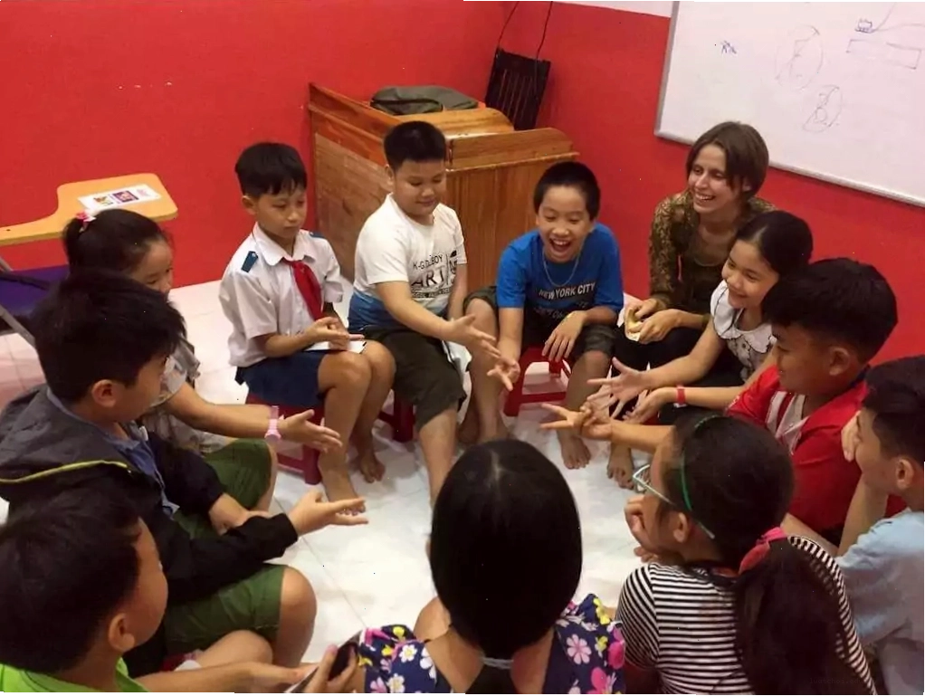 Giáo viên hướng dẫn trẻ em chơi trò chơi học tiếng Anh