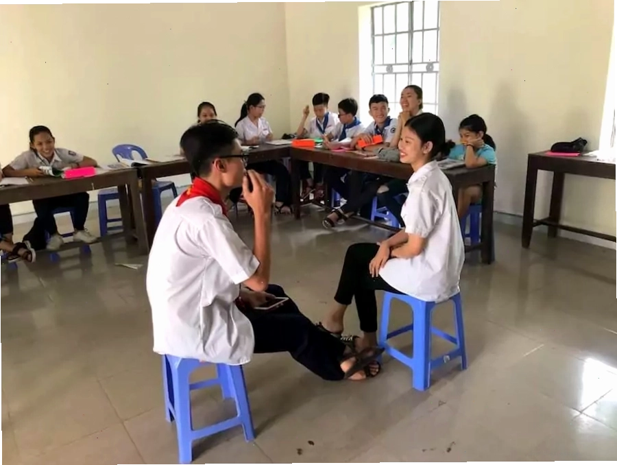 Hai học sinh ESL đang chơi trò chơi đoán chữ trước lớp